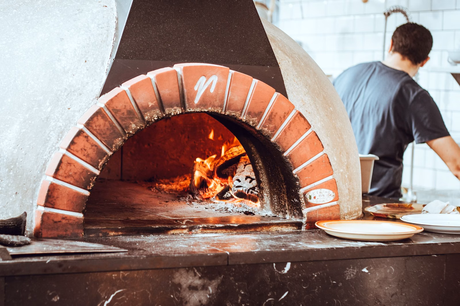 A wood-fired pizza oven with a fire burning inside