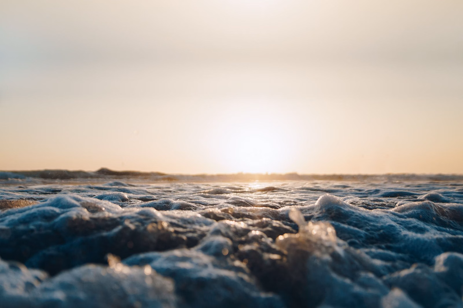 Low sun over the Pacific with waves rolling toward the beach