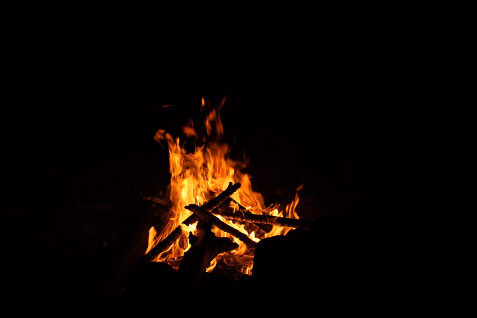 A wood campfire burning at night, allowed only in campground fire rings